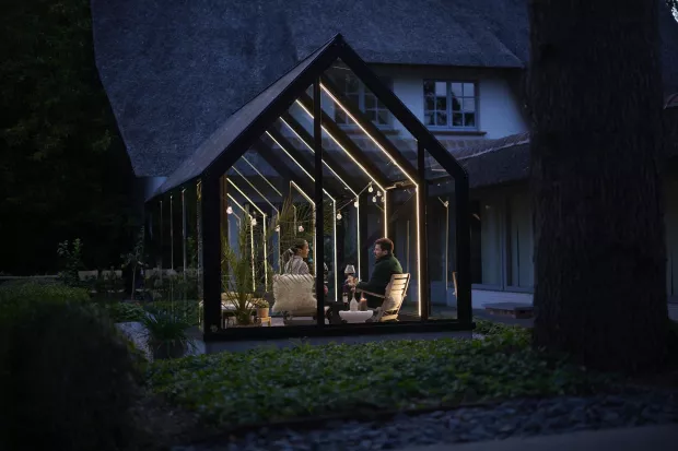 Le couple est assis le soir dans un salon de jardin éclairé